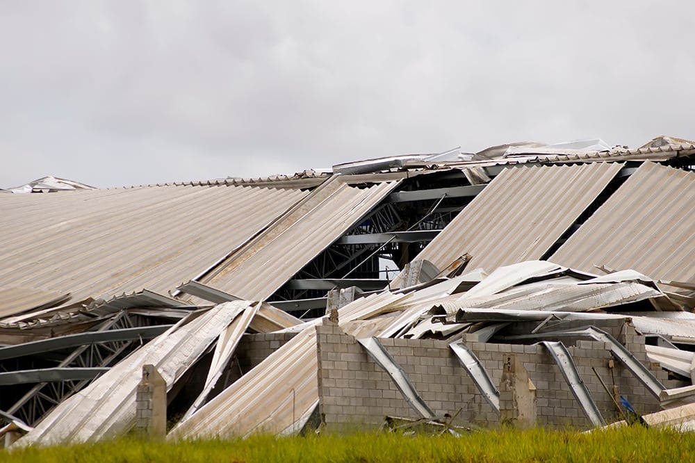 Collapsed industrial roof, damaged metal roof structure.